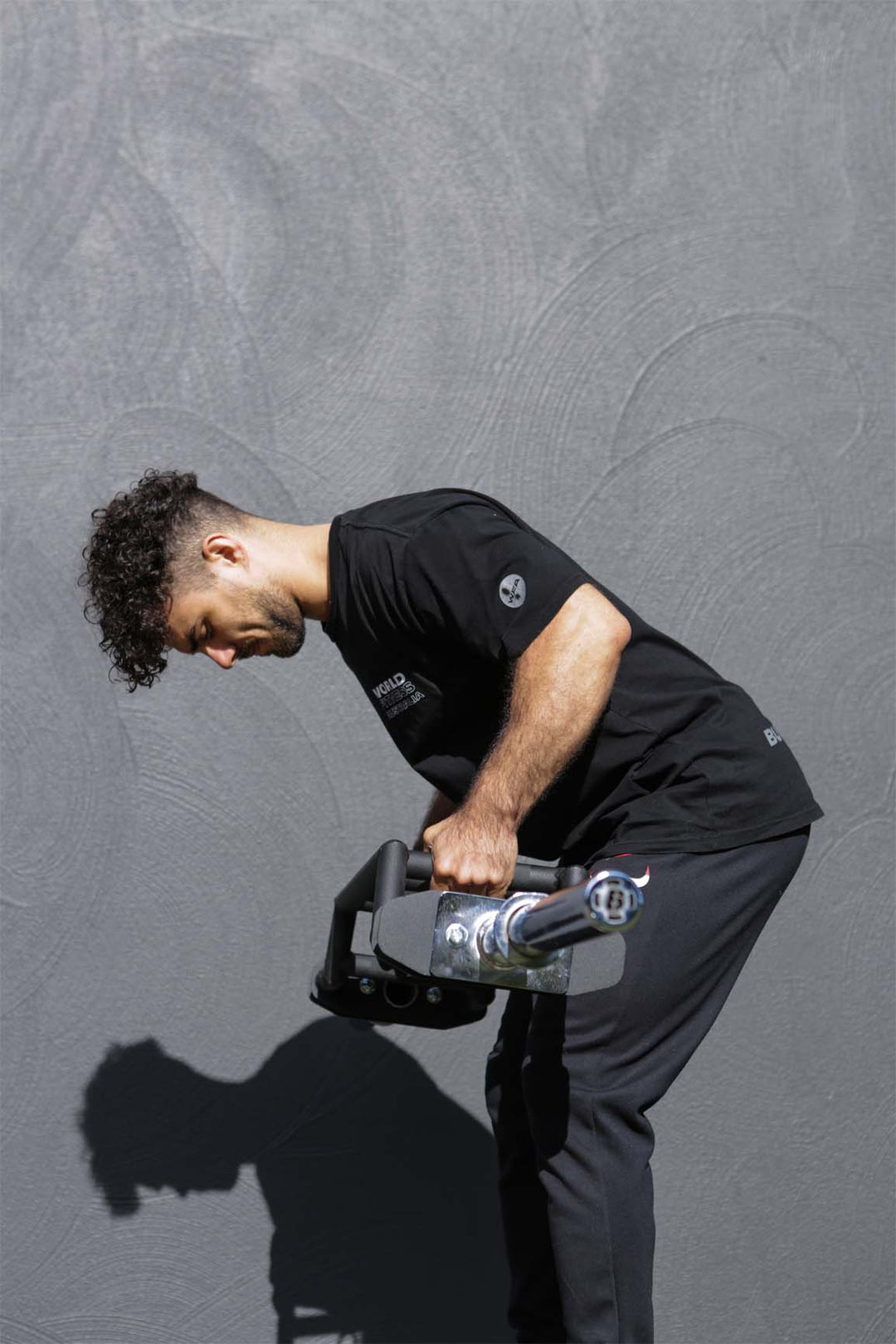 Man performing bent over row with Olympic Swiss barbell